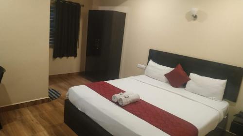 a bedroom with a bed with a teddy bear on it at Hotel raajasgrand in Tirupati