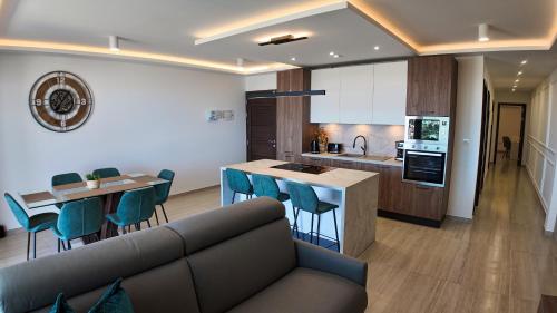 Una sala de estar con un sofá y una cocina. en Skyline Modern Apartment, en Mellieħa