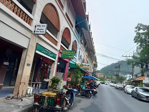 プーケットタウンにあるMitr Inn Phuket Old Town -มิตร อินน์ ภูเก็ตโอลทาวน์の近道に座る人々
