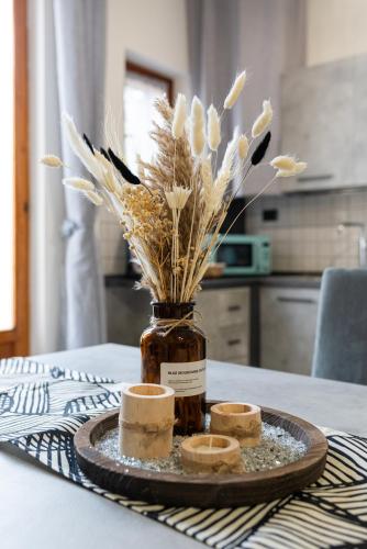 a jar with flowers and two candles on a table at In Centro a Certaldo in Certaldo