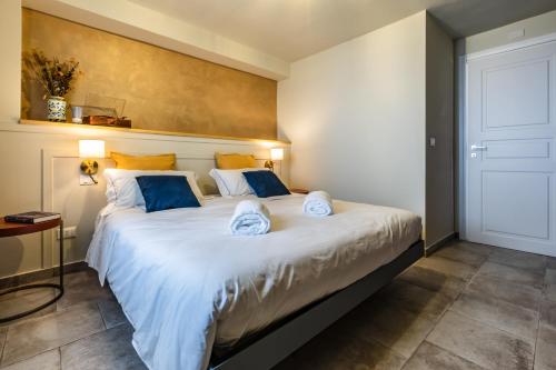 a bedroom with a large white bed with blue pillows at Domus Mea in Forza dʼAgro