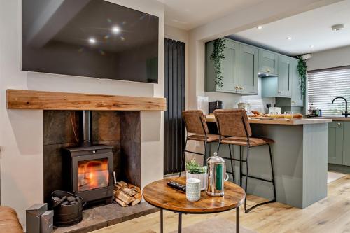 a kitchen and living room with a wood stove at Charming Cosy Cottage in Bollington Village in Bollington