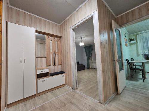 ein Wohnzimmer mit einem weißen Schrank und einem Tisch in der Unterkunft Уютная квартира на Тверская 5, пр Правды, клиника Рохманова in Dnipro