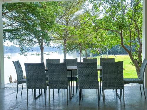 a dining table and chairs with a view of a lake at VAA chachoengsao in Ban Hua Sai
