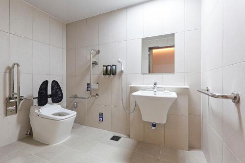 a bathroom with a toilet and a sink at Hotel Deokyeong in Wonju