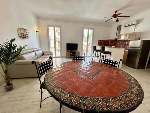 un salon avec une table et une cuisine dans l'établissement Appartement moderne à Juans les Pins de 60 m² avec parking, à Juan-les-Pins