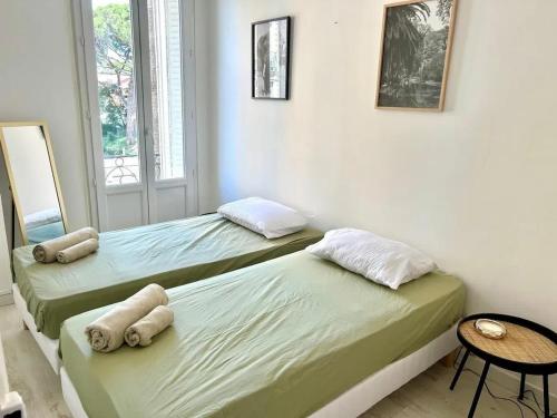 deux lits assis dans une pièce avec une fenêtre dans l'établissement Appartement moderne à Juans les Pins de 60 m² avec parking, à Juan-les-Pins