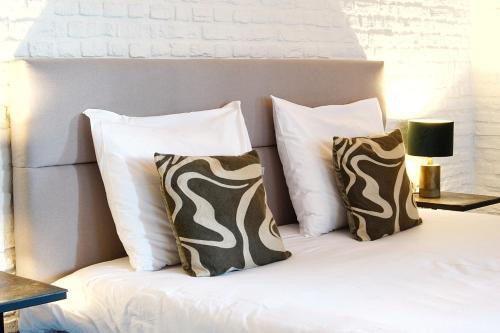 a bed with white pillows and a headboard with at Het Knechthuys in Baarlo