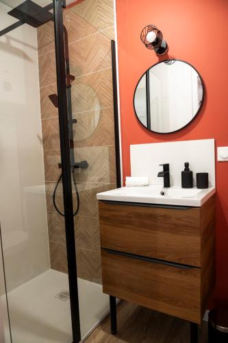 une salle de bain avec un lavabo et un miroir dans l'établissement Le Terracotta - Centre ville, à Marmande