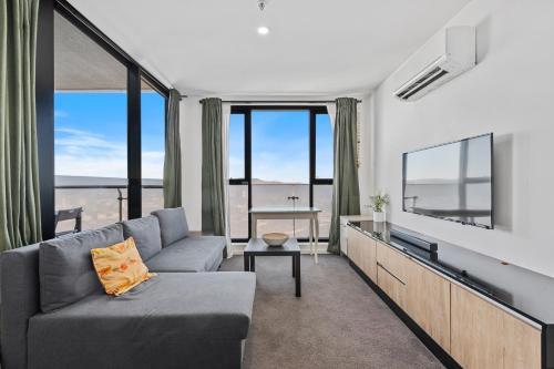 a living room with a couch and a flat screen tv at Pool, Gym & Panoramic Views in Harrison