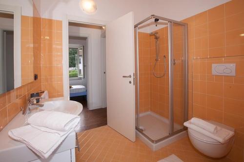 a bathroom with a shower and a toilet and a sink at spiaggia uno pool side apartment in Bellagio