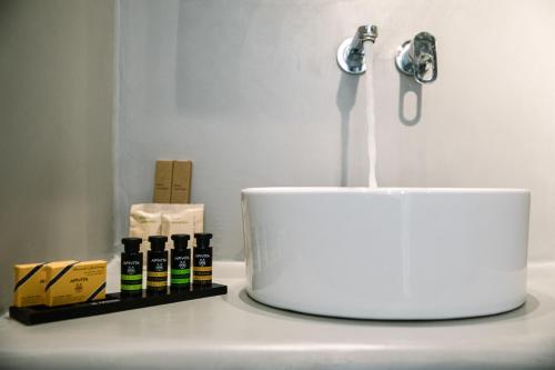 a white sink with a faucet and some bottles on a counter at Kalisti Hotel & Suites in Fira