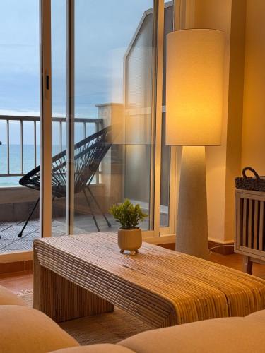 a living room with a table and a view of the ocean at Casa Palmera in Sueca
