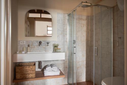 a bathroom with a sink and a glass shower at Il Borghetto - Oliviera loft in San Giovanni dʼAsso