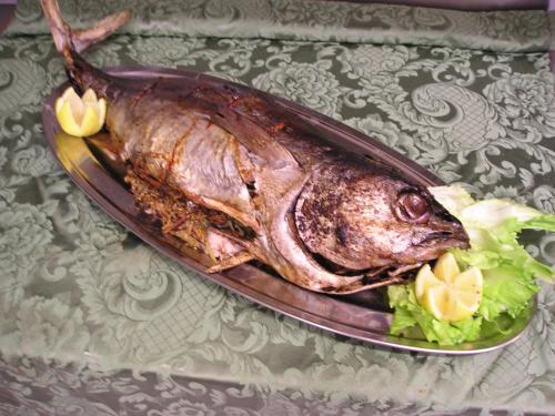 a fish on a plate with lettuce on a table at Hotel Cavalieri in Passignano sul Trasimeno