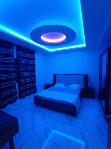 a bedroom with a bed and a blue light at Manessa in Rafrāf