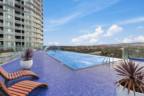 a swimming pool with two chairs and a building at Pool, Gym & Panoramic Views in Harrison
