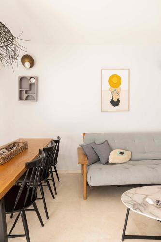 a living room with a couch and a table and chairs at The Beach Life Complex - By Localz Group in Tel Aviv