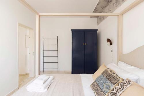 a bedroom with a white bed and a black door at The Beach Life Complex - By Localz Group in Tel Aviv