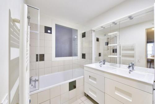 une salle de bain blanche avec une baignoire et un lavabo dans l'établissement Modern 2 BR flat near Vieux Port, à Marseille