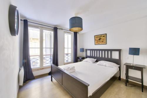 une chambre avec un lit et une grande fenêtre dans l'établissement Modern 2 BR flat near Vieux Port, à Marseille