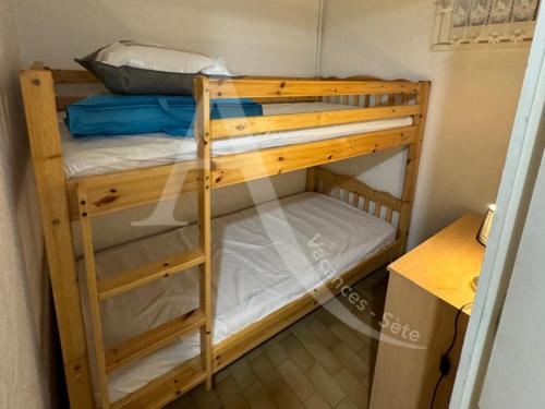 - deux lits superposés dans une petite chambre dans l'établissement Studio cabine avec parking proche de la mer, à Sète