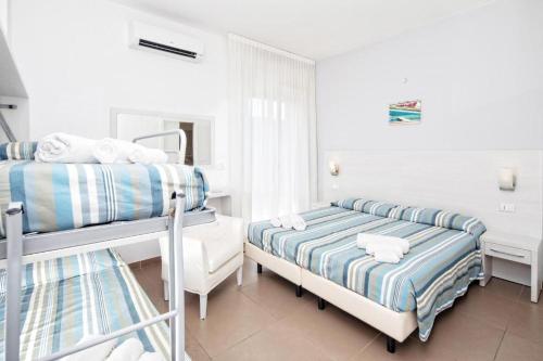 a bedroom with two bunk beds and a mirror at Hotel Gin sul mare in Rimini