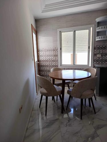 a dining room with a table and chairs and a window at Manessa in Rafrāf
