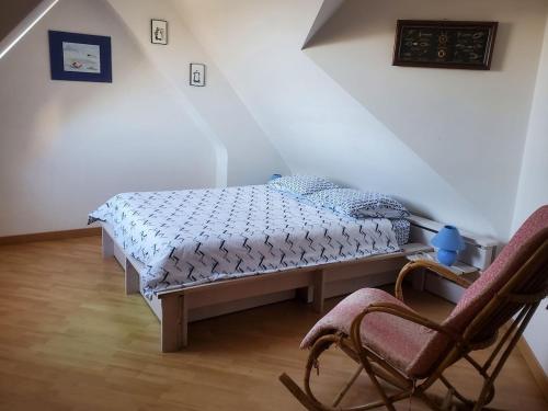 une chambre avec un lit et une chaise dans l'établissement Bellevue, à Crozon