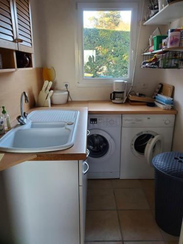 une cuisine avec un évier et une machine à laver dans l'établissement Bellevue, à Crozon