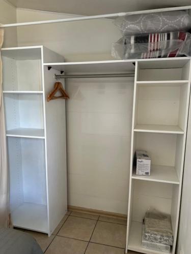 a white closet with white shelves in a room at Escale Terre Rouge in Saint-André