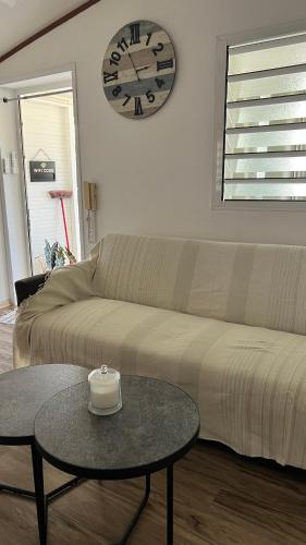 a living room with a couch and a clock on the wall at Escale Terre Rouge in Saint-André