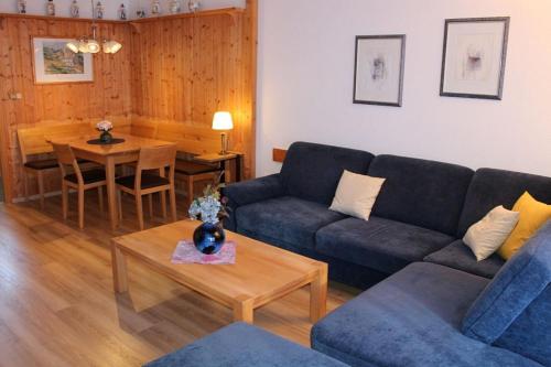 Ferienhaus Nr 121, Kategorie Komfort, Feriendorf Hochbergle, Allgäu في Karlsebene: غرفة معيشة بها أريكة وطاولة