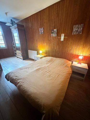 - une chambre avec un grand lit dans un mur en bois dans l'établissement maison de tourisme aux sables d'olonne, à Les Sables-dʼOlonne