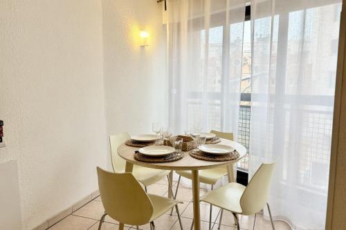 une table à manger avec des chaises blanches et une fenêtre dans l'établissement Apartment with Wifi near beach, à Cannes