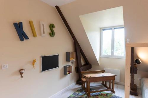 un salon avec une table et une télévision au mur dans l'établissement Le Mayflower 2 à 14 p A 500M DU ZOO!! avec piscine, à Saint-Aignan