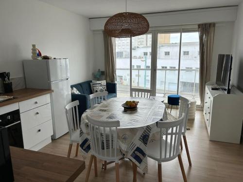 une cuisine et une salle à manger avec une table et des chaises dans l'établissement La roue Bleue, à Saint-Jean-de-Monts
