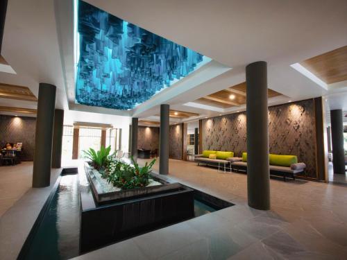 a lobby with a large painting on the wall at Andaman Cannacia Resort & Spa - SHA Extra Plus in Kata Beach