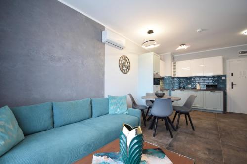 a living room with a blue couch and a table at RentPlanet - Perłowa Przystań in Sianozety