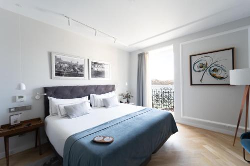 a bedroom with a large bed with a blue blanket at Lasala Plaza Hotel - Adults Only in Donostia-San Sebastián