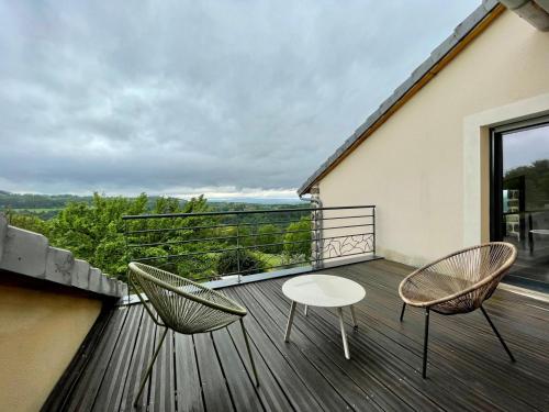 a balcony with two chairs and a table on it at Nouveau Magnifique villa avec jacuzzi in Saint-Julien-Chapteuil