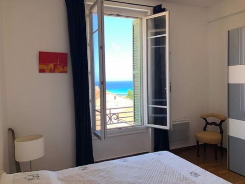 - une chambre avec une fenêtre offrant une vue sur la plage dans l'établissement Appartement Blasini Proche plage & ville, à LʼÎle-Rousse