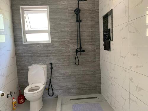 a bathroom with a toilet and a window at Coco Vanille Chalets in Takamaka