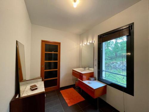 a bathroom with two sinks and a window at Nouveau Magnifique villa avec jacuzzi in Saint-Julien-Chapteuil