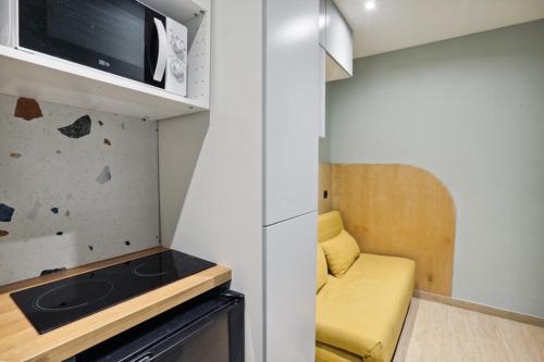 une petite cuisine avec une cuisinière et un micro-ondes dans l'établissement 503 Suite Pergolèse - Charming Studio in Paris 16, à Paris