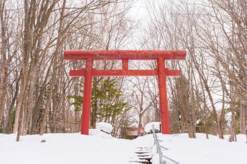 un cancello torii rosso nella neve di Snow Resort Hermitage a Asahikawa