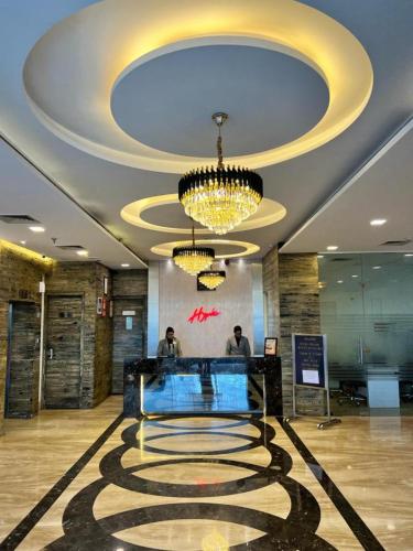 a lobby with a chandelier and a check in counter at Hyphen Premier-Business Hotel in Meerut
