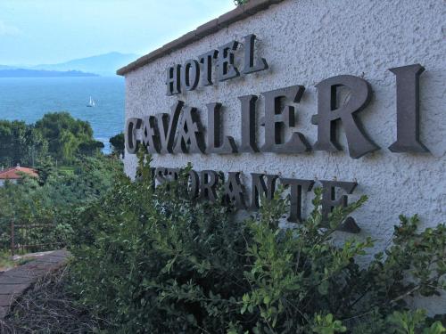 a sign for a hotel on the side of a building at Hotel Cavalieri in Passignano sul Trasimeno