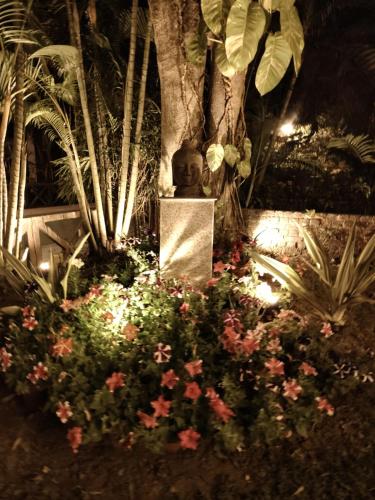 a statue sitting in a garden with flowers at Gardenia 29 in Raichak