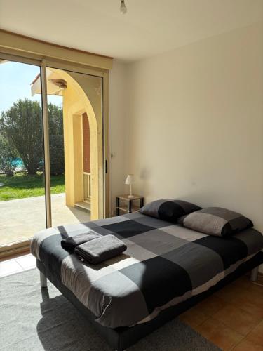 a large bed in a bedroom with a large window at La Villa des Moments Chaleureux in Pompignac